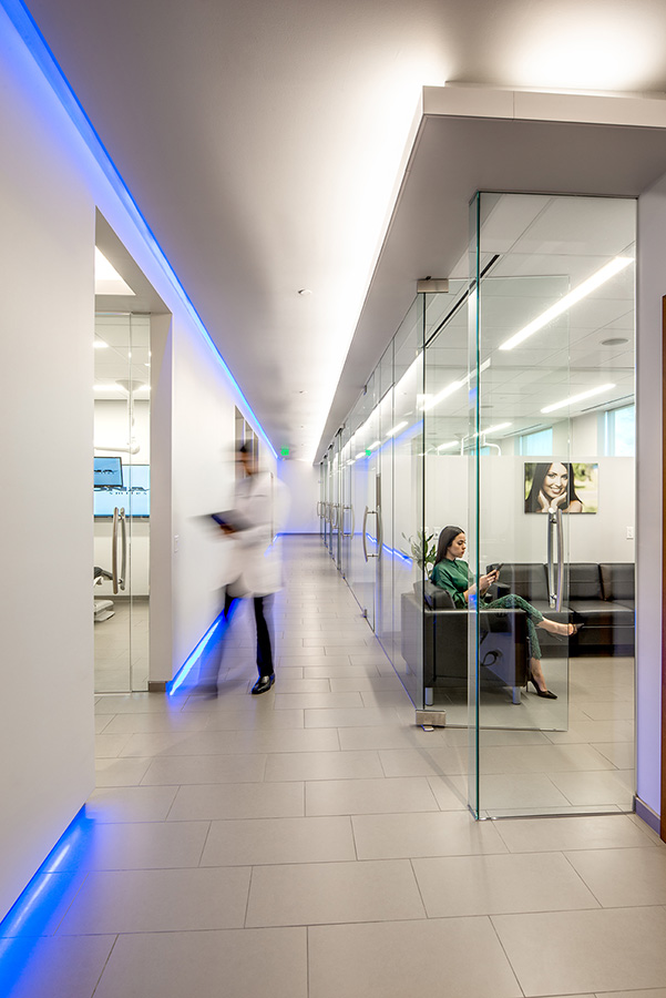 Sleek hallway with glass partitions and blue accent lighting